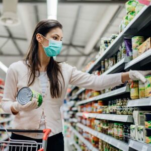 Woman shopping in a grocery store during COVID-19 pandemic. 