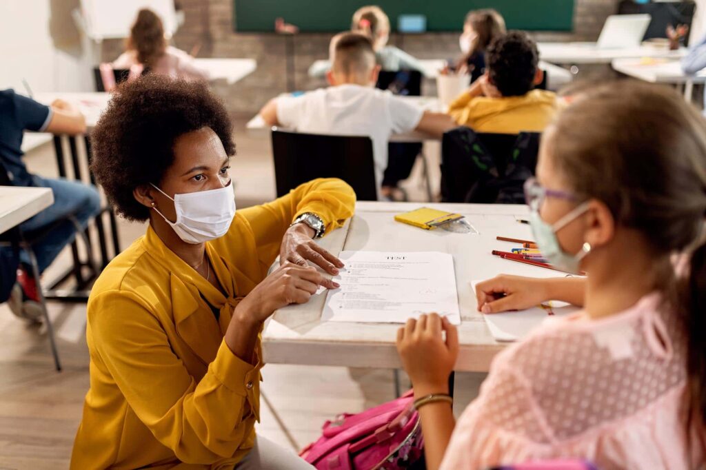 Teacher wearing a mask to protect herself and students from infection. 