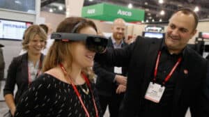 Woman trying out virtual reality goggles at a previous Automation Fair event
