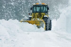 Snow plow cleaning up parking lot after a winter storm