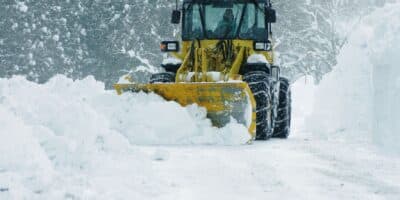 Snow plow cleaning up parking lot after a winter storm