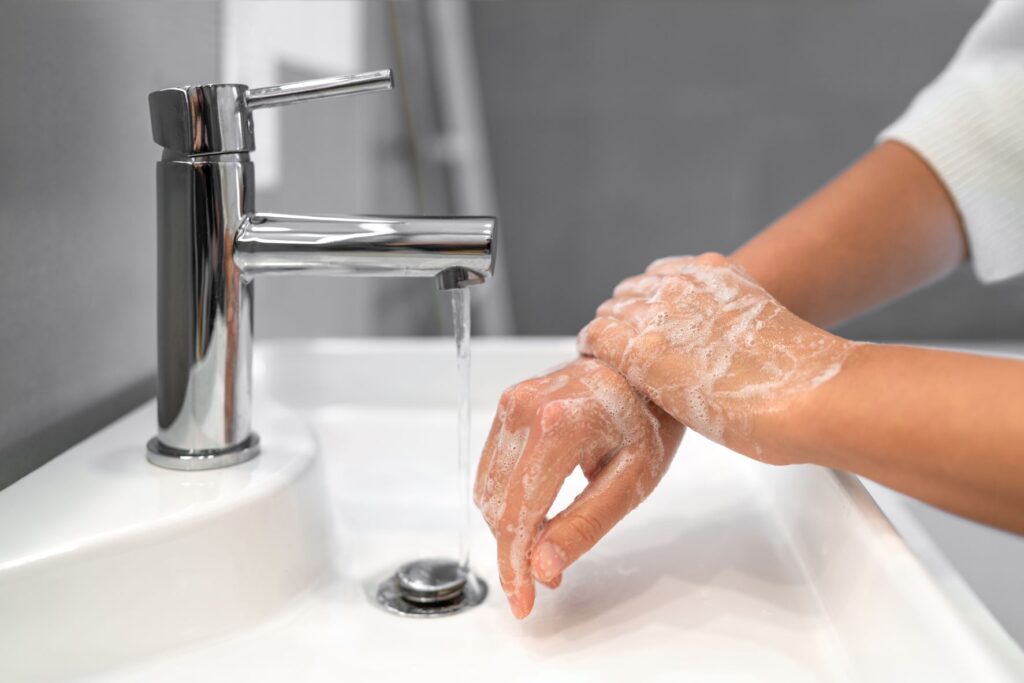 Person washing their hands in the workplace to prevent illness. 