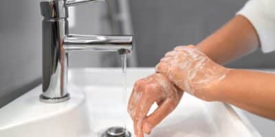 Person washing their hands in the workplace to prevent illness.