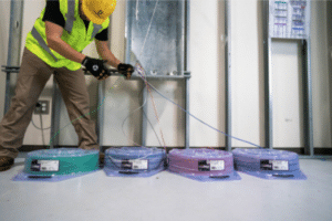Photo of a man using Southwire SIMpull coil packs for wire installation ease.