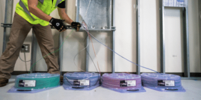 Photo of a man using Southwire SIMpull coil packs for wire installation ease.