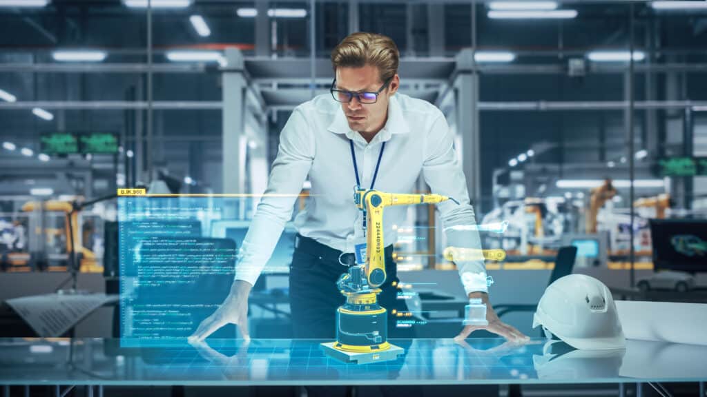 Man working with robot arm in production environment