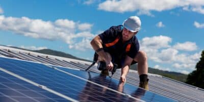 solar integration specialist installing solar energy technology at industrial facility.