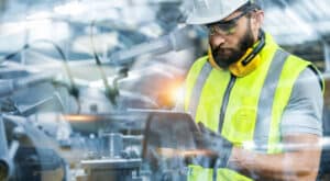 Man on the shop floor evaluating industrial network performance. 