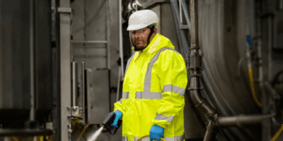 Man wearing raingear in industrial indoor washdown environment.