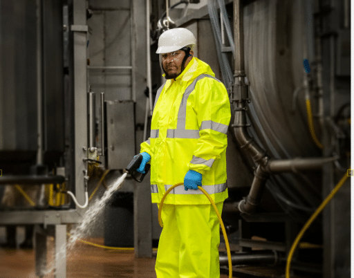 Man wearing raingear in indoor industrial washdown environment. 