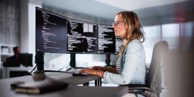 Woman leveraging Belden connectivity technology in industrial controls environment from PC.