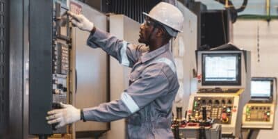 NEC 2026 changes - Electrician working in industrial environment to address code changes.