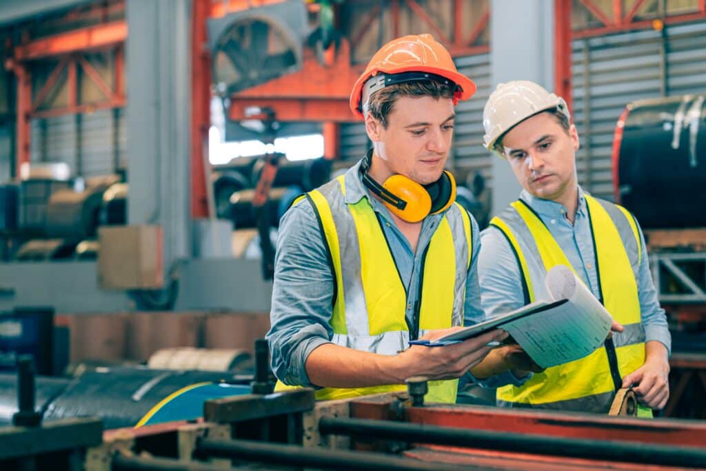 Two production workers collaborating to leverage agility in their manufacturing operations.
