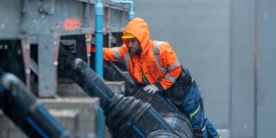 Facilities employee in industrial facility taking storm preparation measures.