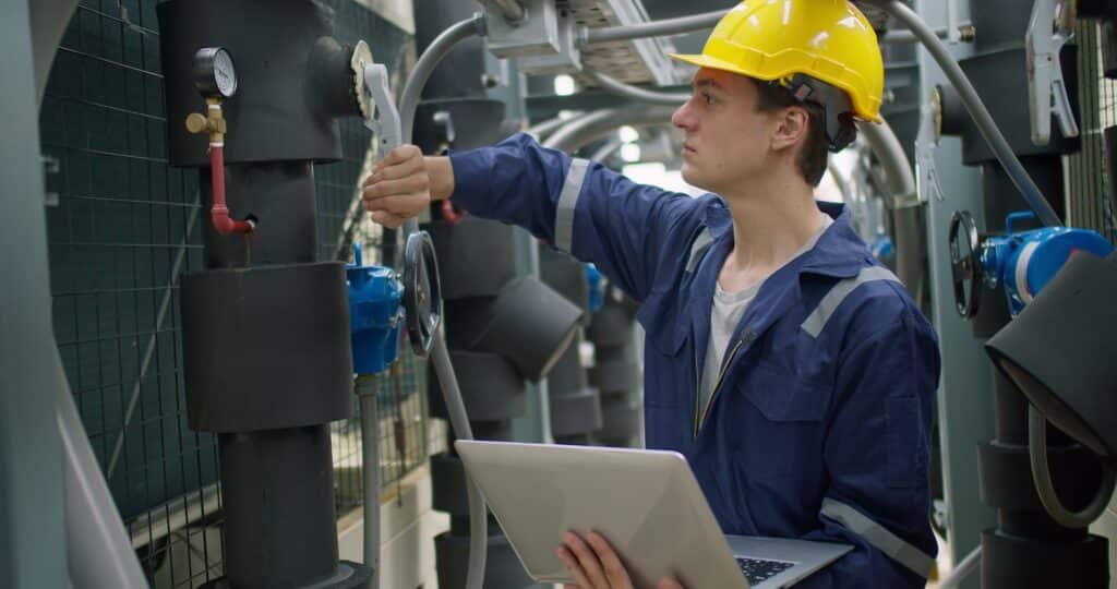 Factory maintenance technician performing predictive maintenance services on equipment.