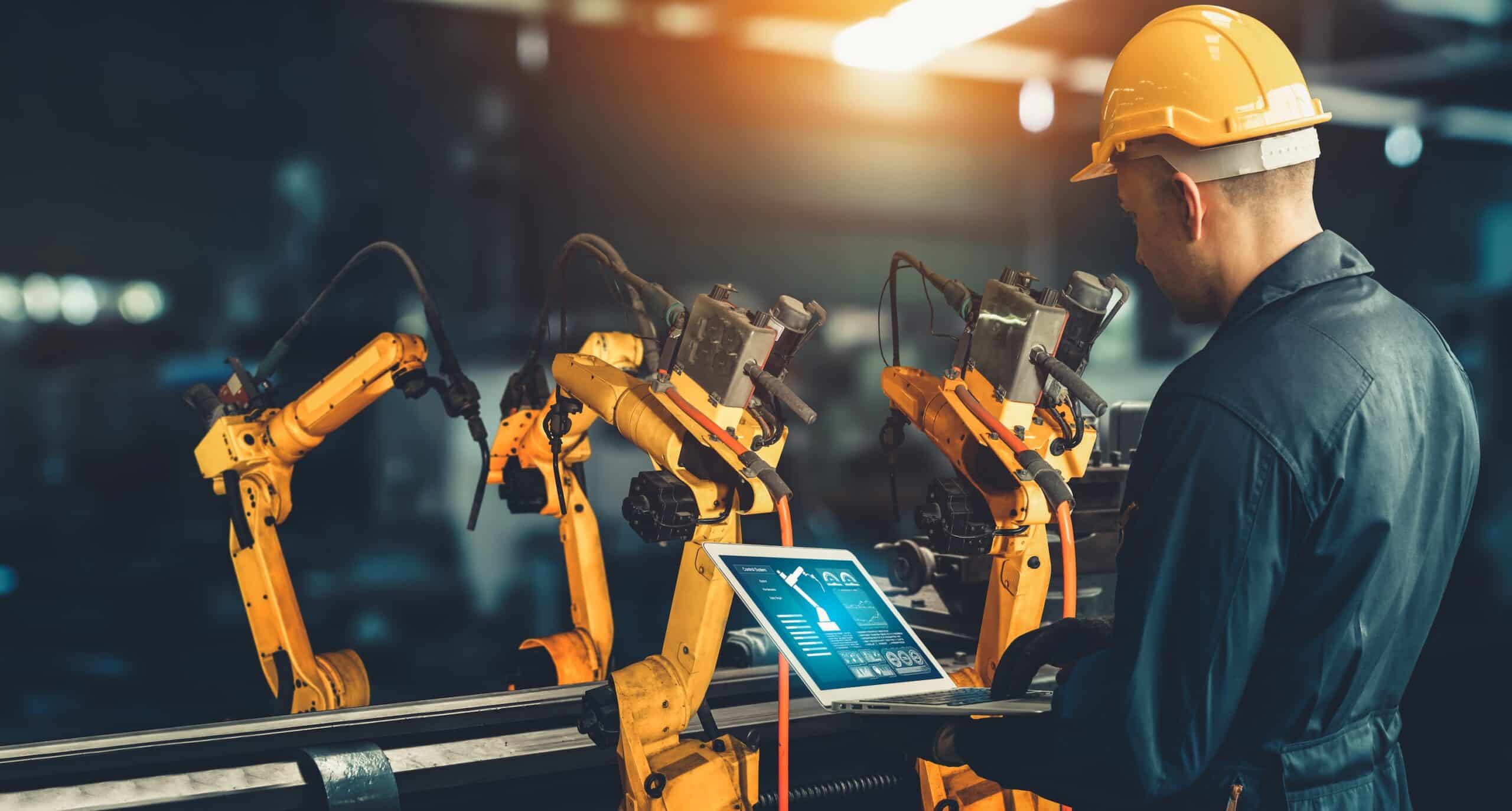 Industrial engineer manipulating robots workers enabled by a strong industrial wireless network.